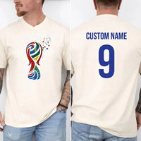 May include a person wearing a cream 2026 World Cup T-shirt featuring bold soccer graphic and relaxed fit.