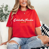 Person wearing a red t-shirt with 'Celebrating Freedom Since 1776' text, sitting on a couch.