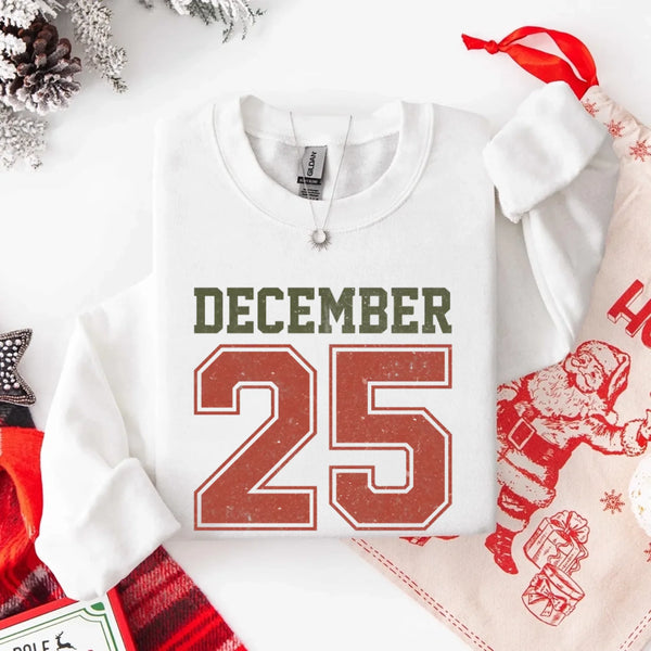 May include a retro-style Christmas sweatshirt featuring bold varsity lettering that reads “December 25” in green and red. The design has a vintage, slightly distressed look, giving it a nostalgic holiday feel perfect for festive winter wear.