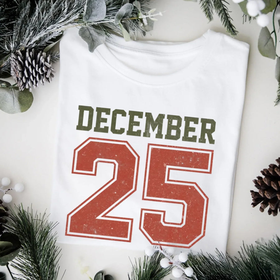 May include a retro-style Christmas sweatshirt featuring bold varsity lettering that reads “December 25” in green and red. The design has a vintage, slightly distressed look, giving it a nostalgic holiday feel perfect for festive winter wear.