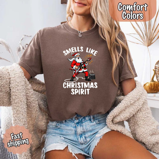 May include a Comfort Colors unisex t-shirt featuring a vintage-style Santa Claus graphic and the text “Smells Like Christmas Spirit” printed on soft cotton fabric.