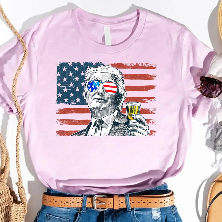 Pink t-shirt with a graphic of a man holding a drink against an American flag background.