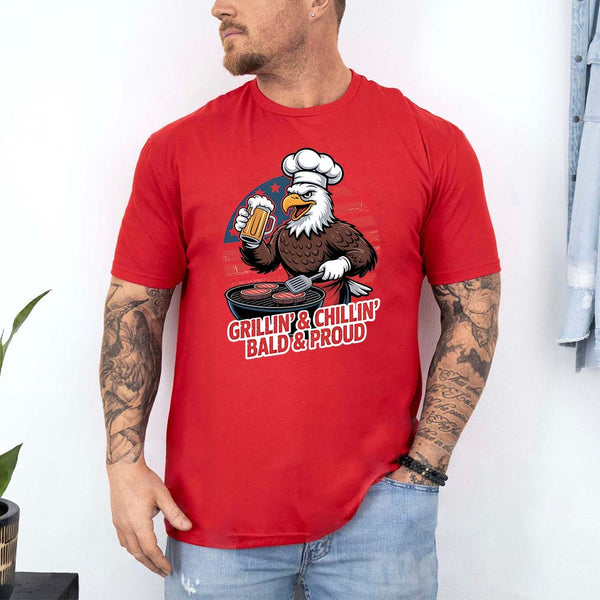 Man wearing a red t-shirt with an eagle graphic and text, standing against a white wall.