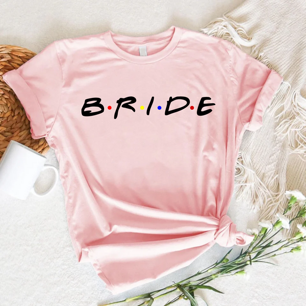 Blush pink T-shirt with text reading "Bride,"