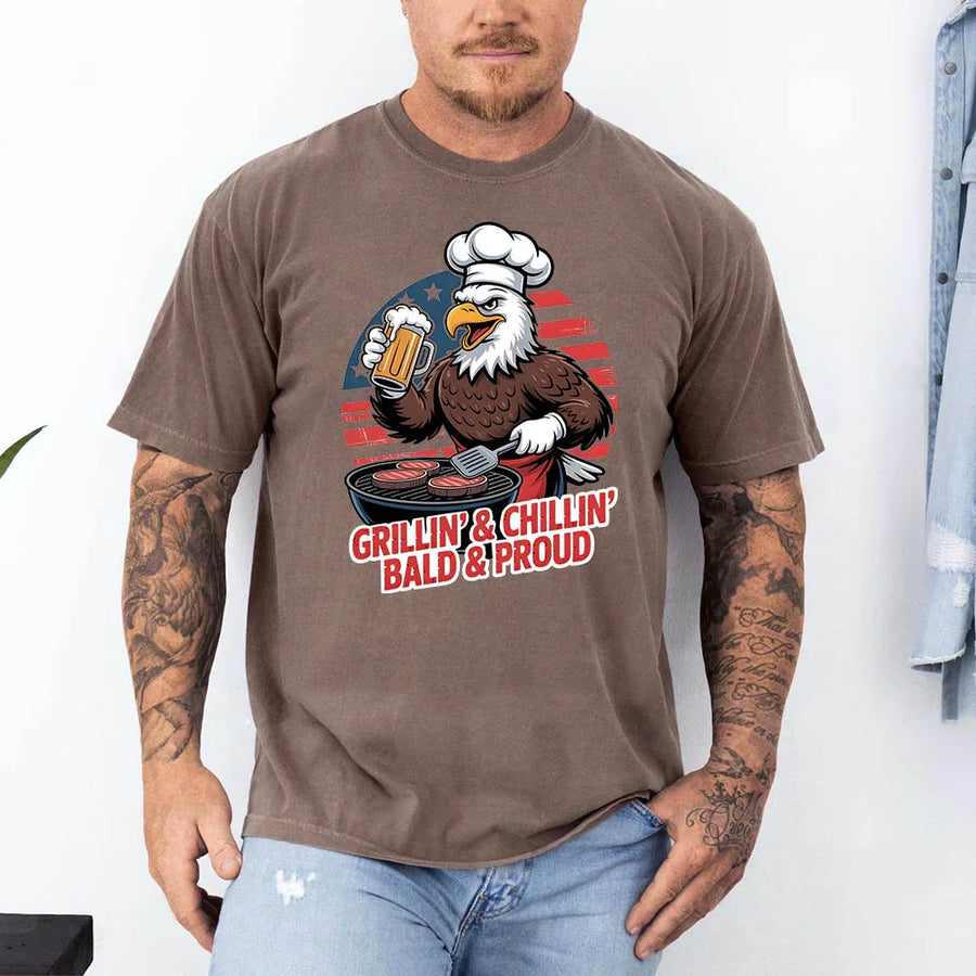 Man wearing a brown t-shirt with an eagle graphic and text, standing against a white background.
