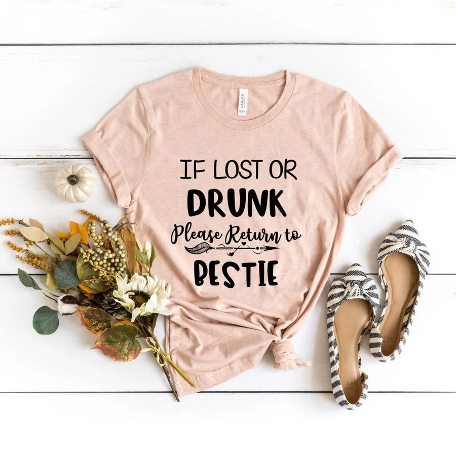 Light Peach t-shirt with humorous text on a white wooden surface with flowers and shoes.