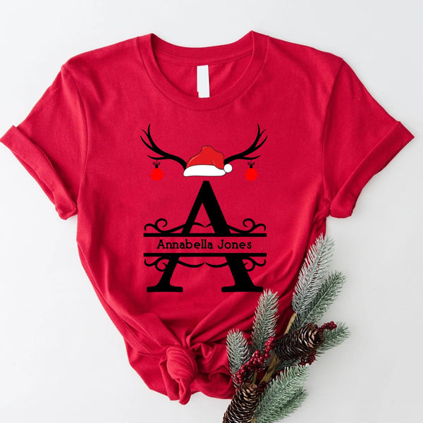 May include a personalized Christmas T-shirt with a single initial printed in a holiday-themed design on the front.