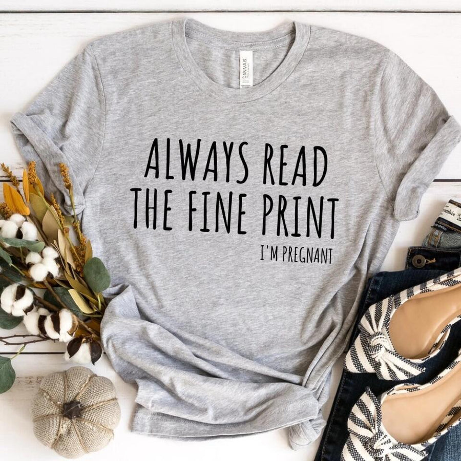 Gray custom tee with 'Always read the fine print I'm pregnant' text, styled flat lay.