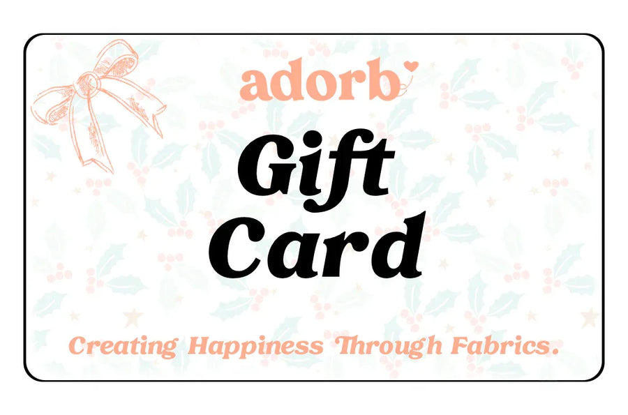 Gift card with holiday holly background, bow illustration, and text 'Creating Happiness Through Fabrics.'