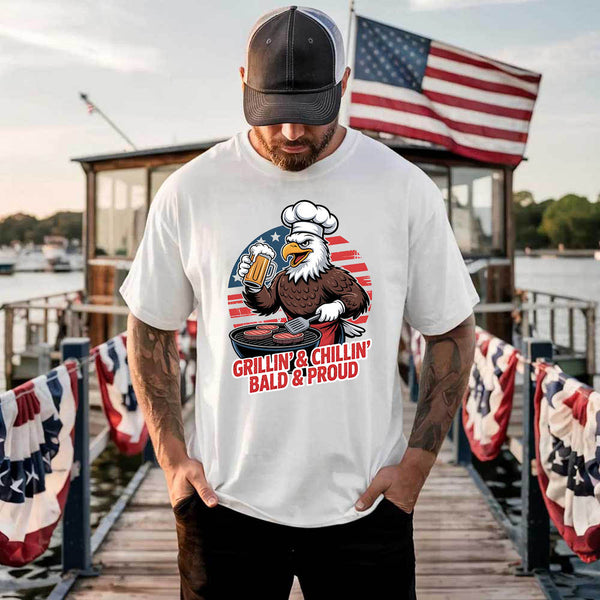Man wearing a white t-shirt with an eagle graphic and text on a dock with American flags.