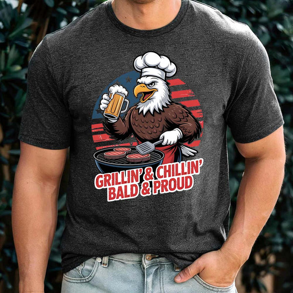 Person wearing a dark gray t-shirt with an eagle graphic and text 'Grillin' & Chillin' Bald & Proud'.