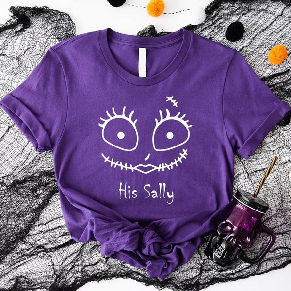 Purple t-shirt with a face design and text 'His Sally' on a Halloween-themed background.
