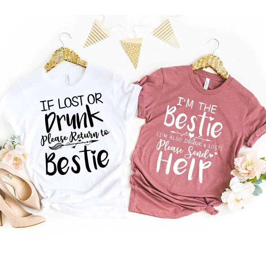 Two t-shirts with humorous text designs on hangers with decorative elements.