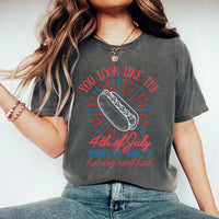 Person wearing a t-shirt with a graphic and text, standing against a plain background