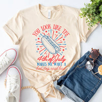 Beige t-shirt with 4th of July graphic design, paired with white sneakers and denim shorts on a light background.