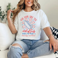 Person wearing a white t-shirt with a colorful graphic and text, sitting on a couch.