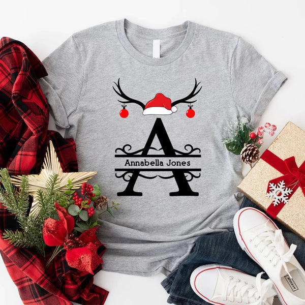 May include a personalized Christmas T-shirt with a single initial printed in a holiday-themed design on the front.