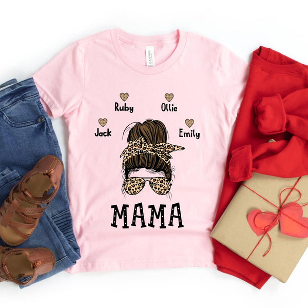 Pink t-shirt with 'MAMA' and child names graphic, surrounded by jeans, shoes, and a gift box.