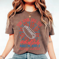 Person wearing a brown t-shirt with a hot dog graphic and text on a white background