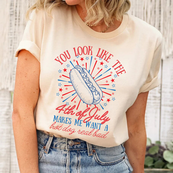 Person wearing a t-shirt with a hot dog graphic and text, standing against a neutral background.