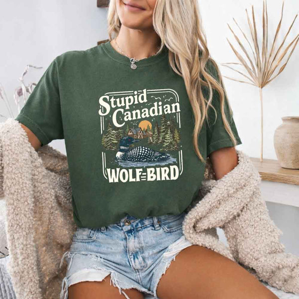 May include a person wearing a Moss Stupid Canadian Wolf-Bird Comfort Colors T-Shirt featuring sports romance inspired graphic and relaxed fit.