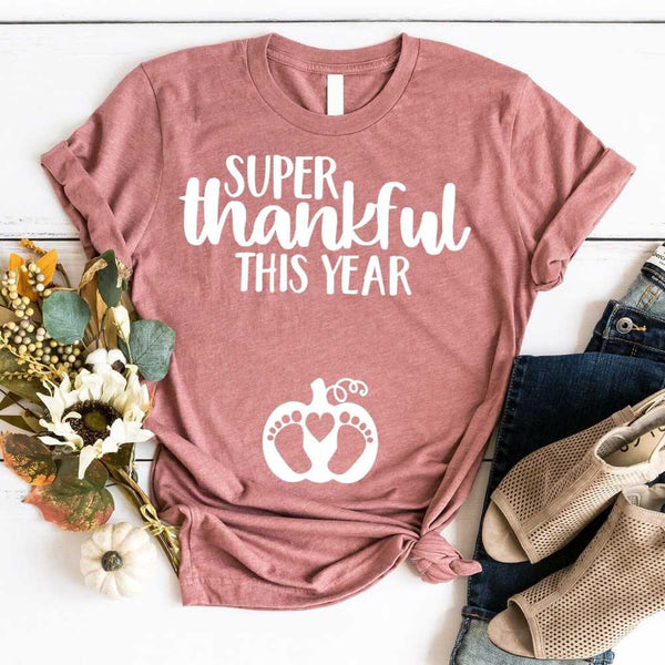 May include a unisex t-shirt with the phrase ‘Super Thankful For This Year,’ printed in a warm fall color palette, styled for Thanksgiving and autumn wear.