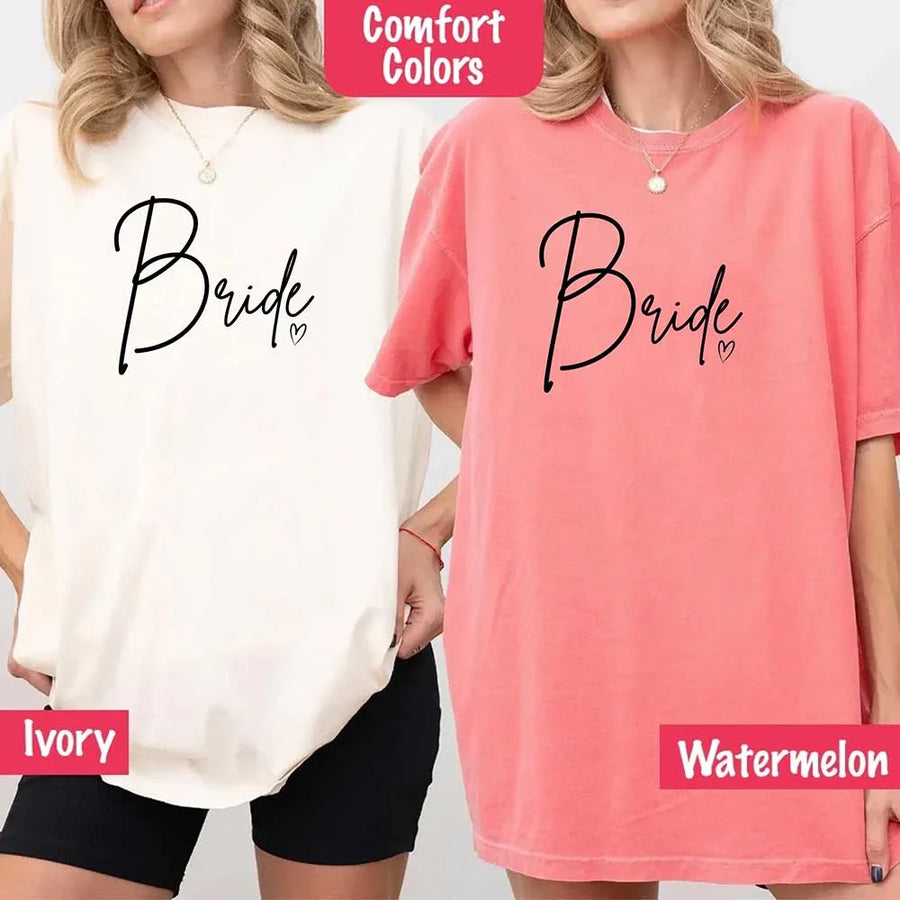 Matching “Bride” graphic tees in ivory and pink, oversized fit, worn over black bike shorts with layered pendant necklaces.
