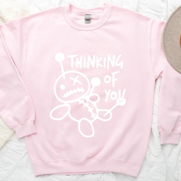 May include a t-shirt featuring the phrase “Thinking About You” in a clean or artistic font style. The design may use soft or minimalist colors, conveying a thoughtful, sentimental, or romantic message suitable for casual wear.