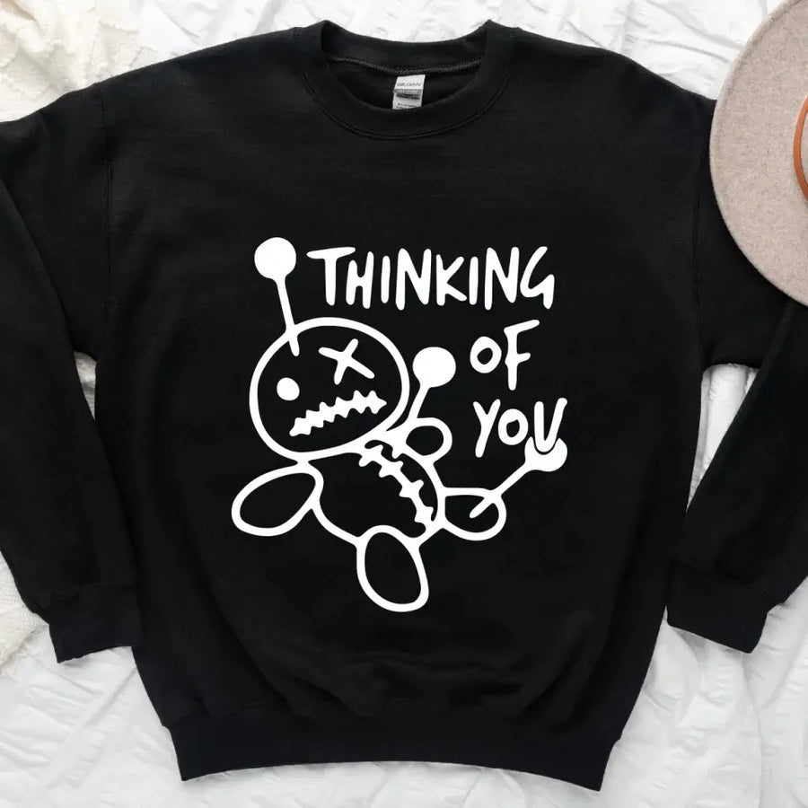 May include a t-shirt featuring the phrase “Thinking About You” in a clean or artistic font style. The design may use soft or minimalist colors, conveying a thoughtful, sentimental, or romantic message suitable for casual wear.