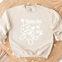 May include a t-shirt featuring the phrase “Thinking About You” in a clean or artistic font style. The design may use soft or minimalist colors, conveying a thoughtful, sentimental, or romantic message suitable for casual wear.