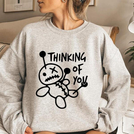 May include a t-shirt featuring the phrase “Thinking About You” in a clean or artistic font style. The design may use soft or minimalist colors, conveying a thoughtful, sentimental, or romantic message suitable for casual wear.