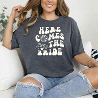 May include Dark Heather bachelorette-themed T-shirt reading “Vino Before Vows,” featuring playful typography and celebratory bridal party design elements!