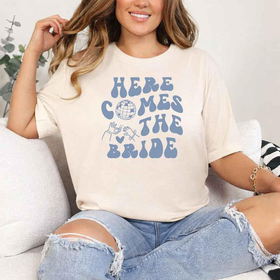 May include Soft Cream bachelorette-themed T-shirt reading “Vino Before Vows,” featuring playful typography and celebratory bridal party design elements!