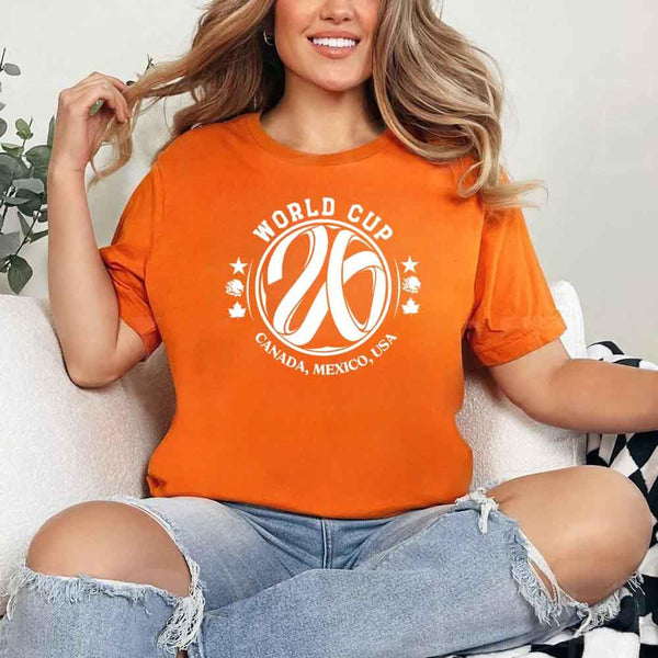 May include a person wearing an Orange colored 2026 World Cup T-shirt featuring bold soccer graphic and relaxed fit.