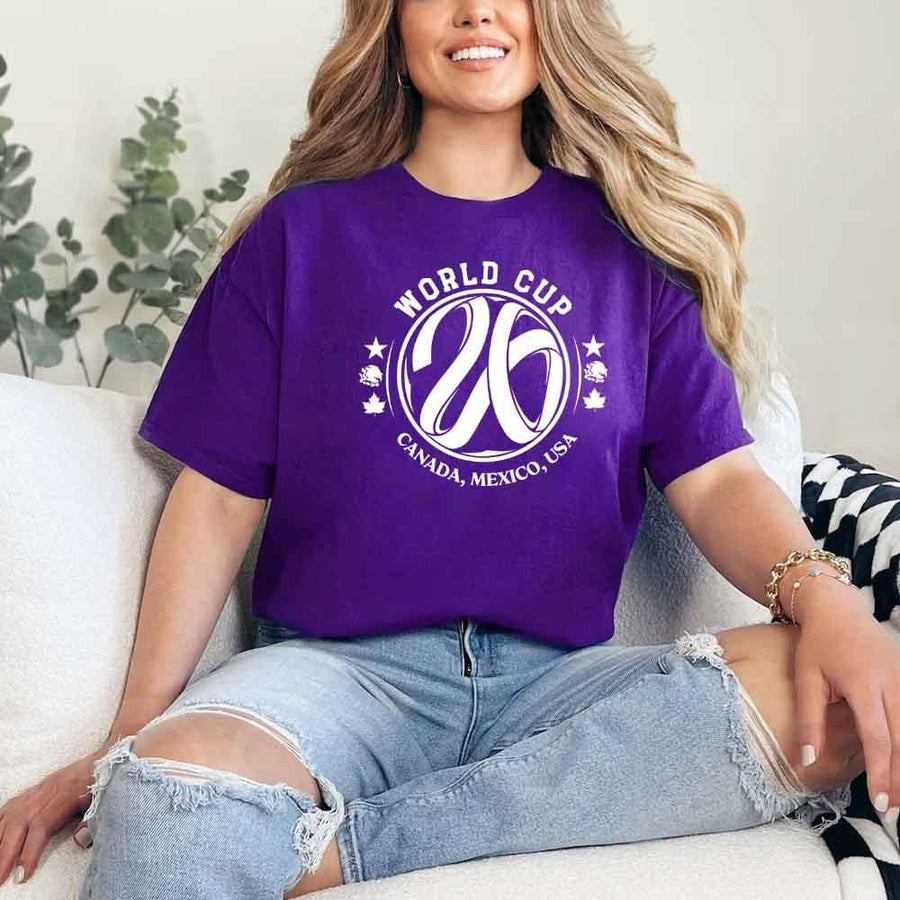 May include a person wearing a Purple colored 2026 World Cup T-shirt featuring bold soccer graphic and relaxed fit.