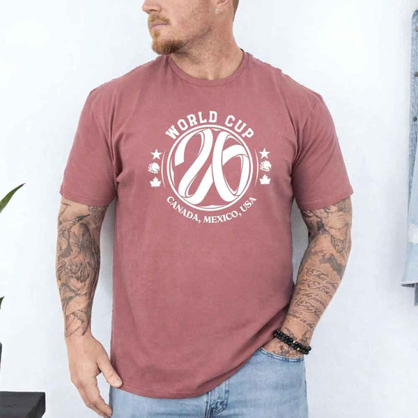 May include a person wearing a Mauve colored 2026 World Cup T-shirt featuring bold soccer graphic and relaxed fit.