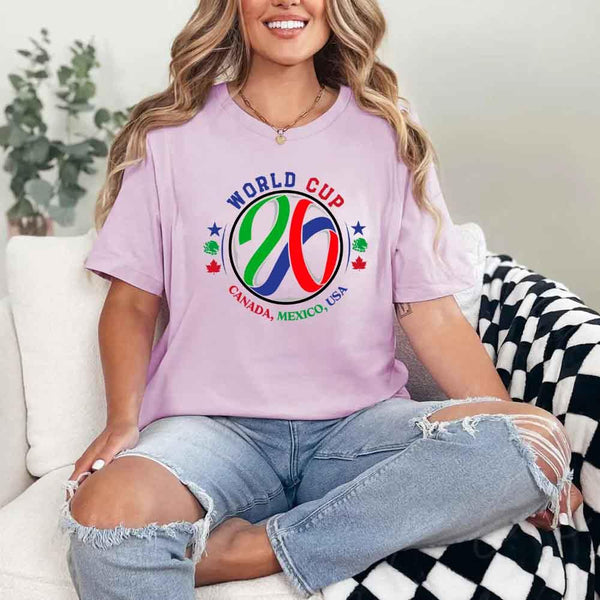 May include a person wearing a Lilac colored 2026 World Cup T-shirt featuring bold soccer graphic and relaxed fit.