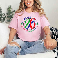 May include a person wearing a Pink colored 2026 World Cup T-shirt featuring bold soccer graphic and relaxed fit.