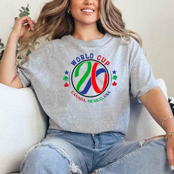 May include a person wearing a Sport Grey colored 2026 World Cup T-shirt featuring bold soccer graphic and relaxed fit.