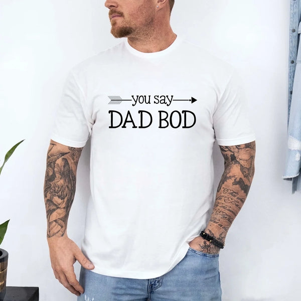 May include a person wearing a funny dad graphic t-shirt with the phrase “You Say Dad Bod, I Say Father Figure”.