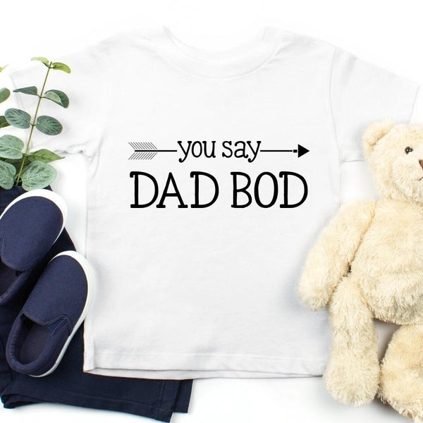 May include a person wearing a funny dad graphic t-shirt with the phrase “You Say Dad Bod, I Say Father Figure”.