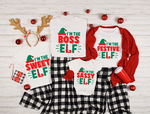 May include a toddler Christmas tee with a playful elf graphic printed on the front, presented on a plain background.